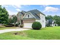 Brick-and-siding exterior elevation of a charming two-story home with a two-car garage and manicured landscaping at 378 Oak Alley Trl, Clayton, NC 27527