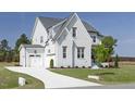 Elegant two-story home with a white brick facade and a spacious two-car garage at 3913 Berkeley Town Ln, Fuquay Varina, NC 27526