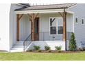 Inviting front porch with wooden pillars and a stylish black railing at 3913 Berkeley Town Ln, Fuquay Varina, NC 27526