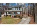 Two-story townhome with brick facade, green shutters, and a long driveway at 402 Shannonford Ct, Wake Forest, NC 27587