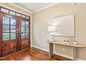 Welcoming foyer with hardwood floors, a decorative table, and a glass-paneled front door at 48 Grandwood Cir, Durham, NC 27712