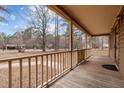 Inviting front porch with wooden floor and railings offering a serene outdoor space and a view of the yard at 582 Pollyanna Rd, Henderson, NC 27537