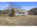 Inviting single-story home featuring light gray vinyl siding and well-kept yard, blending comfort and curb appeal at 59 Tristan Dr, Kenly, NC 27542