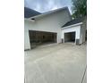 Attached white two-car garage with stone accents and spacious concrete driveway at 60 Valebrook Ct, Youngsville, NC 27596