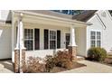 Inviting front porch with brick accents and well-manicured landscaping adds curb appeal at 613 Flaherty Ave, Wake Forest, NC 27587