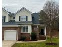 Two-story brick and siding home with an attached garage and a beautifully landscaped yard at 7710 Astoria Pl, Raleigh, NC 27612