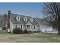 Traditional home with dormer windows, brick chimney, and attached three-car garage at 8510 Polaris Dr, Bahama, NC 27503