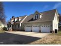 Home featuring an attached three-car garage and a paved driveway, perfect for parking and curb appeal at 8510 Polaris Dr, Bahama, NC 27503