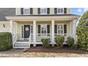 Inviting front porch with white columns and dark shutters adding curb appeal at 8712 New River Cir, Raleigh, NC 27603