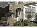 Brick home entrance with arched doorway and meticulous landscaping at 9244 Palm Bay Cir, Raleigh, NC 27617
