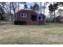 View of cozy one-story brick home on a lawn with mature trees at 103 W Thorndale Dr, Oxford, NC 27565