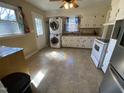 Functional kitchen featuring white appliances, modern washer and dryer, and rainbow light reflection at 103 W Thorndale Dr, Oxford, NC 27565