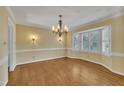 Formal dining room featuring hardwood floors, chandelier, and natural light from a bay window at 113 Bonner Ct, Cary, NC 27511