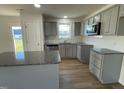 Modern kitchen boasting gray cabinets, granite countertops, a stylish backsplash, and stainless steel appliances at 12 Flatland Dr, Princeton, NC 27569
