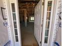 Open doorway revealing the unfinished interior of a home under construction with exposed framework and natural light at 124 Willow Cameron Way, Angier, NC 27501