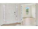 Bright foyer with hardwood floors, white walls, and a view into another room through french doors at 124 Willow Cameron Way, Angier, NC 27501