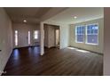 Open-concept living room featuring wood floors, white trim, and plenty of natural light from the many windows at 124 Willow Cameron Way, Angier, NC 27501