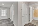 Hallway featuring wood-look flooring, neutral paint, and doors leading to a bedroom and bathroom at 1723 Starlit Sky Ln, Cary, NC 27519