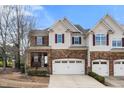 Charming townhome featuring a stone facade, two-car garage, and well-maintained landscaping at 1800 Pierre Pl, Apex, NC 27502