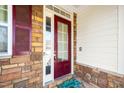 Close-up of a welcoming front door with sidelight and decorative hardware set in a stone archway at 1800 Pierre Pl, Apex, NC 27502