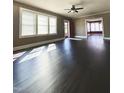 Spacious living room with gleaming dark hardwood floors and abundant natural light from large windows at 1922 Oxford Rd, Henderson, NC 27536