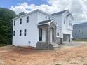 Side view of a new two-story home showcasing white siding, stone accents, and garage at 212 Fast Pitch Ln, Four Oaks, NC 27524