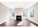 Cozy living room featuring a fireplace, hardwood floors, and plenty of natural light at 212 Wildwood Ln, Graham, NC 27253