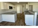 Modern kitchen featuring white cabinetry, granite countertops, stainless steel microwave, and wood flooring at 24 Heatherglenn Cir, Princeton, NC 27569