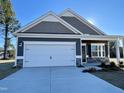 Beautiful two-story home with gray siding, stone accents, and a two-car garage at 242 Deodora Ln, Cameron, NC 28326