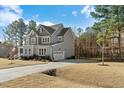 Gray two-story home with landscaped yard, white trim, a two-car garage, and long driveway at 2504 Georgianna Dr, Wake Forest, NC 27587