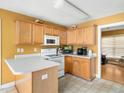 Functional kitchen with wooden cabinets, white appliances, and laminate countertops at 2574 Primrose Ln, Creedmoor, NC 27522