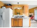 Another view of the kitchen featuring a double sink, dishwasher, and view to living room at 2574 Primrose Ln, Creedmoor, NC 27522