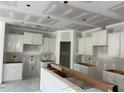 Unfinished kitchen featuring white cabinets and drywall, showcasing a spacious layout awaiting final touches at 277 Gregory Village Dr, Lillington, NC 27546