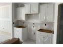 Unfinished kitchen featuring white cabinets and drywall, showcasing a spacious layout awaiting final touches at 277 Gregory Village Dr, Lillington, NC 27546