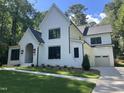 Stunning two-story home with white brick, black trim, attached garage, and a beautifully landscaped yard at 3513 Eden Croft Dr, Raleigh, NC 27612
