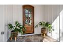 Close up of stunning wooden front door with glass, white trim, stone floor, and decorative plants at 3513 Eden Croft Dr, Raleigh, NC 27612