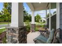 Cozy front porch featuring stone pillars, seating and views of the surrounding neighborhood at 3528 Olive Glen Dr, Apex, NC 27502