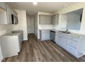 Well-lit kitchen with gray cabinets, granite countertops, and wood-look flooring at 38 Flatland Dr, Princeton, NC 27569