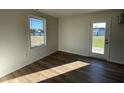 Bright room with wood-look flooring, a large window, and access to the backyard at 38 Flatland Dr, Princeton, NC 27569