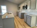 Modern kitchen showcasing granite counters, stainless steel microwave, and stylish backsplash at 39 Flatland Dr, Princeton, NC 27569