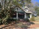 Alluring two-story home with lovely landscaping, awnings over a screened in porch, and a brick walkway at 405 N Massey St, Selma, NC 27576