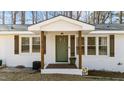 Close-up of the charming green front door with decorative shutters and covered front porch at 4775 Barber Mill Rd, Clayton, NC 27520