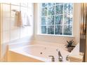 Bright bathroom with a white tiled tub and a large window offering a view of nature at 503 Gray Marble Rd, Morrisville, NC 27560