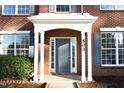 Close up of the front door on a charming brick home with white columns and blue door at 503 Gray Marble Rd, Morrisville, NC 27560
