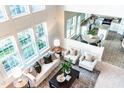 Bright living room with vaulted ceilings and many windows featuring a view to the kitchen and dining area at 503 Gray Marble Rd, Morrisville, NC 27560