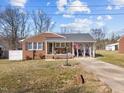 Charming brick home featuring a covered front porch, gray roof, and a well-maintained front yard at 74 Azalea Dr, Roxboro, NC 27573