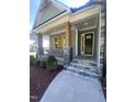 Inviting front porch featuring stone accents, wooden columns, and wrought iron railings at 80 Valebrook Ct, Youngsville, NC 27596