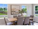 Dining room with natural light, stylish table, and seating for six at 805 Windmill Palm Dr, Zebulon, NC 27597