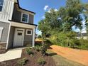 Side exterior of a light gray home with a stone facade and lovely landscaped yard at 82 Fairwinds Dr, Lillington, NC 27546