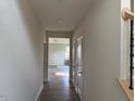 Bright hallway with hardwood floors, white walls, and doors leading to multiple rooms, creating an open and inviting space at 82 Fairwinds Dr, Lillington, NC 27546